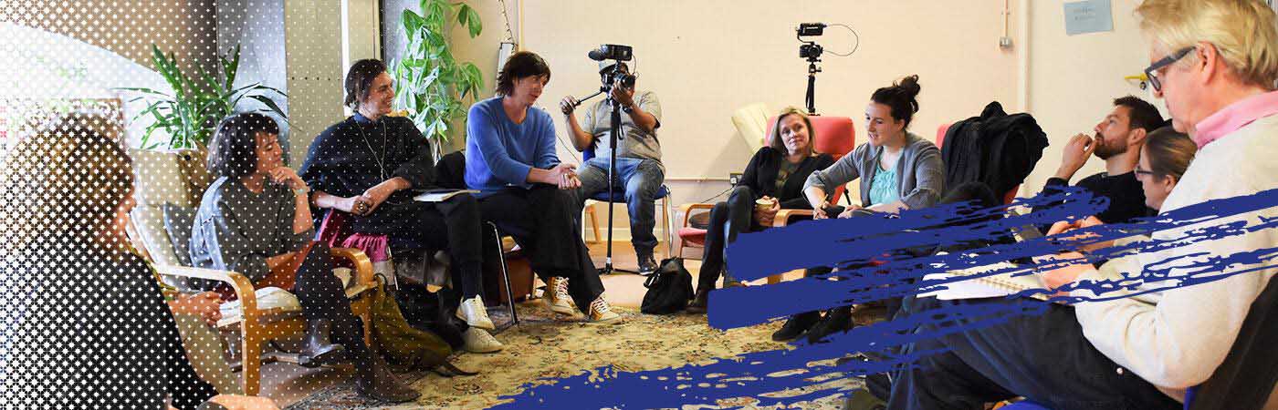 A group of individuals being filmed whilst in conversation